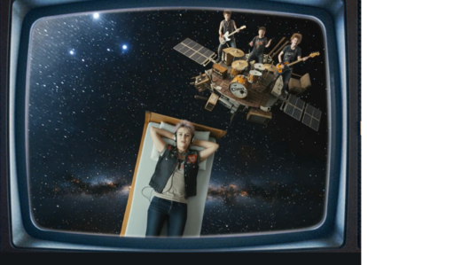 Still aus Trailer zum Song zu Mauerpogo von Sonja M. Schultz. Abgebildet wird ein Mädchen, das auf einem Bett liegt, das im Universum fliegt, dahinter eine spielende Band
