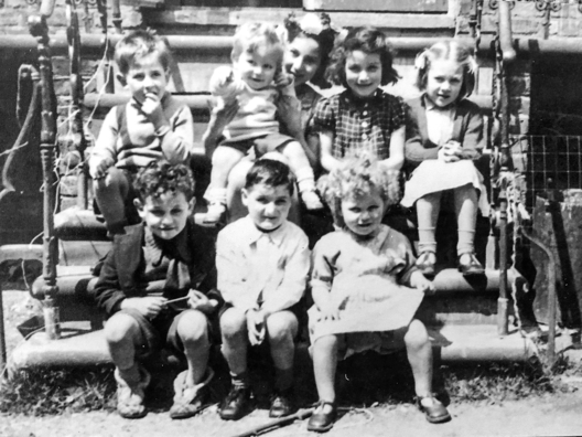 Historischen schwarz-weiss-Foto. Zu sehen sind eine Frau mit sieben kleinen Kindern.