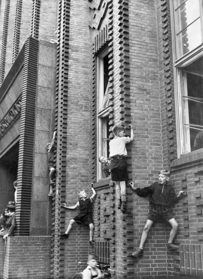 Kinder klettern an Fassade