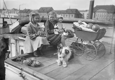 Mädchen mit Puppen auf einem Boot