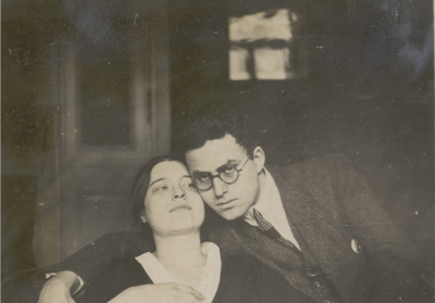  Schwarz-weiss Foto von Netty Reiling und Rodi. Er umarmt sie und schaut in die Kamera, sie ist zurückgeleht und schaut nach oben