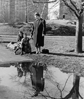 Schwarz-weiss-Fotografie von Fred Stein. Abgebildet wird eine Frau mit zwei kleinen Mädchn in einem Park.